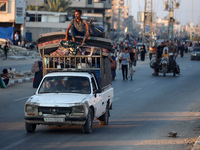 Displaced Palestinians are leaving al-Bureij refugee camp towards the west, after the Israeli army issued a new evacuation order, in the cen...