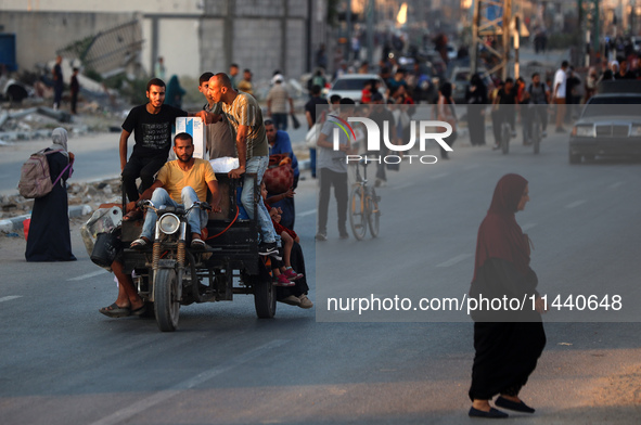 Displaced Palestinians are leaving al-Bureij refugee camp towards the west, after the Israeli army issued a new evacuation order, in the cen...