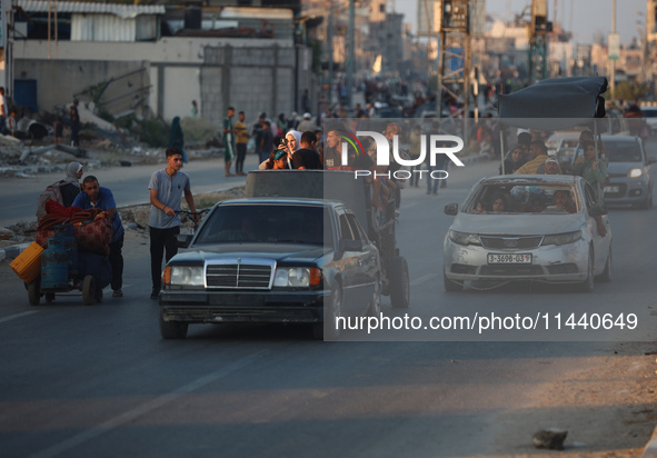 Displaced Palestinians are leaving al-Bureij refugee camp towards the west, after the Israeli army issued a new evacuation order, in the cen...