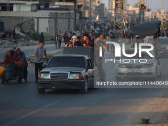 Displaced Palestinians are leaving al-Bureij refugee camp towards the west, after the Israeli army issued a new evacuation order, in the cen...