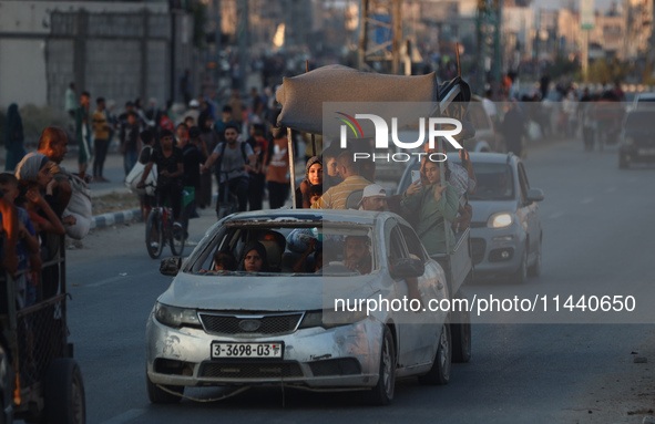 Displaced Palestinians are leaving al-Bureij refugee camp towards the west, after the Israeli army issued a new evacuation order, in the cen...