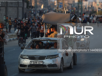 Displaced Palestinians are leaving al-Bureij refugee camp towards the west, after the Israeli army issued a new evacuation order, in the cen...