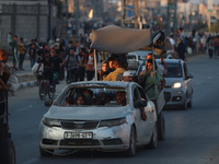 Displaced Palestinians are leaving al-Bureij refugee camp towards the west, after the Israeli army issued a new evacuation order, in the cen...