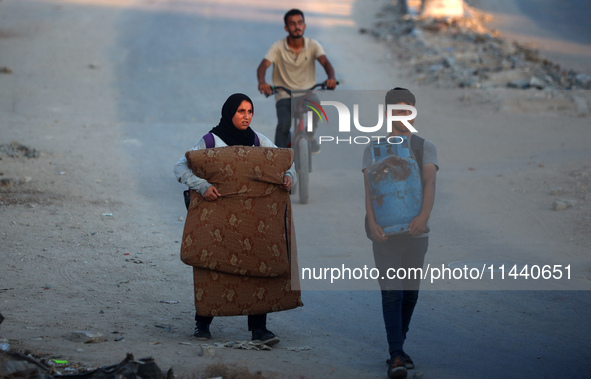 Displaced Palestinians are leaving al-Bureij refugee camp towards the west, after the Israeli army issued a new evacuation order, in the cen...