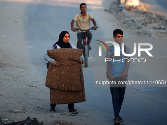 Displaced Palestinians are leaving al-Bureij refugee camp towards the west, after the Israeli army issued a new evacuation order, in the cen...