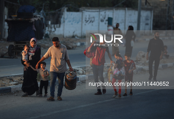 Displaced Palestinians are leaving al-Bureij refugee camp towards the west, after the Israeli army issued a new evacuation order, in the cen...