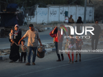 Displaced Palestinians are leaving al-Bureij refugee camp towards the west, after the Israeli army issued a new evacuation order, in the cen...