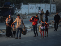 Displaced Palestinians are leaving al-Bureij refugee camp towards the west, after the Israeli army issued a new evacuation order, in the cen...