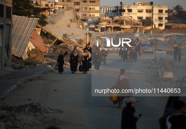 Displaced Palestinians are leaving al-Bureij refugee camp towards the west, after the Israeli army issued a new evacuation order, in the cen...