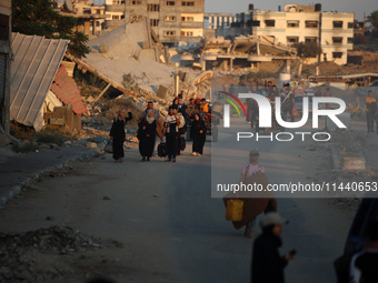 Displaced Palestinians are leaving al-Bureij refugee camp towards the west, after the Israeli army issued a new evacuation order, in the cen...