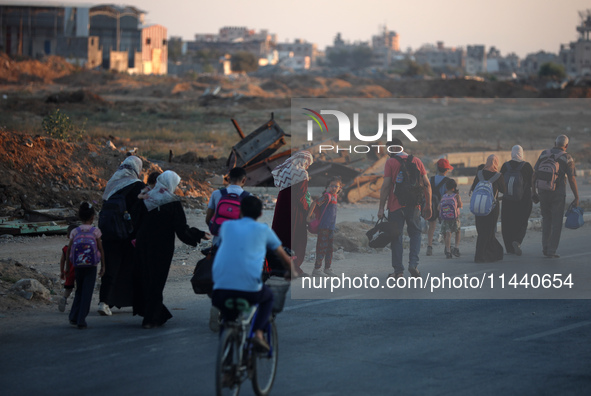 Displaced Palestinians are leaving al-Bureij refugee camp towards the west, after the Israeli army issued a new evacuation order, in the cen...