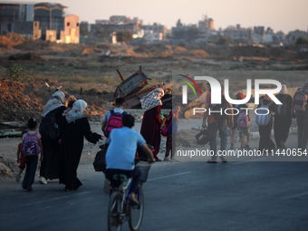 Displaced Palestinians are leaving al-Bureij refugee camp towards the west, after the Israeli army issued a new evacuation order, in the cen...