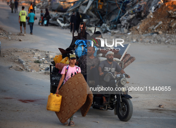 Displaced Palestinians are leaving al-Bureij refugee camp towards the west, after the Israeli army issued a new evacuation order, in the cen...