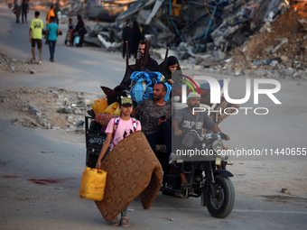 Displaced Palestinians are leaving al-Bureij refugee camp towards the west, after the Israeli army issued a new evacuation order, in the cen...