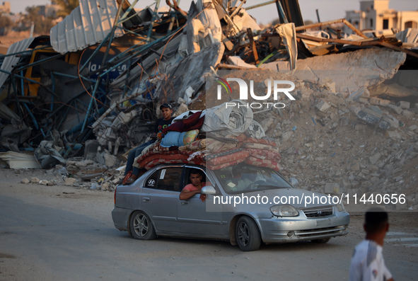 Displaced Palestinians are leaving al-Bureij refugee camp towards the west, after the Israeli army issued a new evacuation order, in the cen...