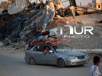 Displaced Palestinians are leaving al-Bureij refugee camp towards the west, after the Israeli army issued a new evacuation order, in the cen...