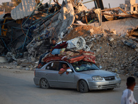 Displaced Palestinians are leaving al-Bureij refugee camp towards the west, after the Israeli army issued a new evacuation order, in the cen...