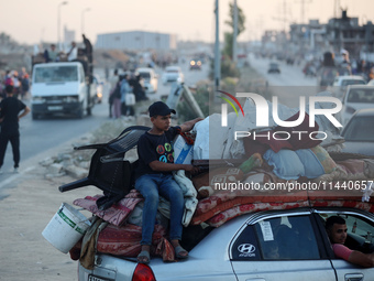 Displaced Palestinians are leaving al-Bureij refugee camp towards the west, after the Israeli army issued a new evacuation order, in the cen...