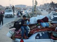 Displaced Palestinians are leaving al-Bureij refugee camp towards the west, after the Israeli army issued a new evacuation order, in the cen...