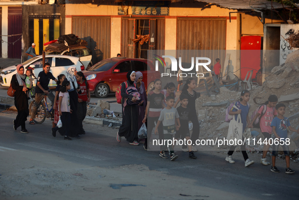 Displaced Palestinians are leaving al-Bureij refugee camp towards the west, after the Israeli army issued a new evacuation order, in the cen...