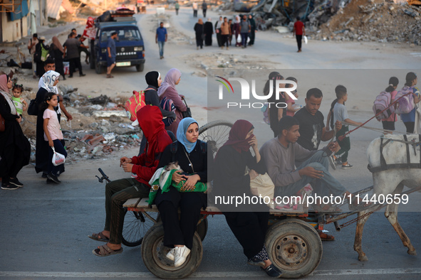 Displaced Palestinians are leaving al-Bureij refugee camp towards the west, after the Israeli army issued a new evacuation order, in the cen...