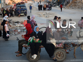 Displaced Palestinians are leaving al-Bureij refugee camp towards the west, after the Israeli army issued a new evacuation order, in the cen...