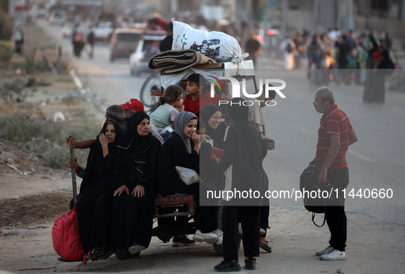 Displaced Palestinians are leaving al-Bureij refugee camp towards the west, after the Israeli army issued a new evacuation order, in the cen...