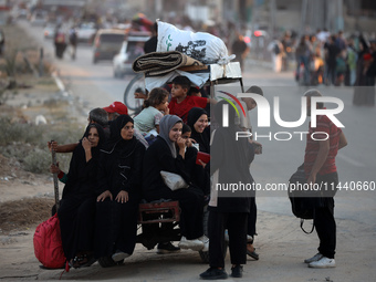 Displaced Palestinians are leaving al-Bureij refugee camp towards the west, after the Israeli army issued a new evacuation order, in the cen...