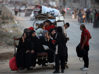 Displaced Palestinians are leaving al-Bureij refugee camp towards the west, after the Israeli army issued a new evacuation order, in the cen...