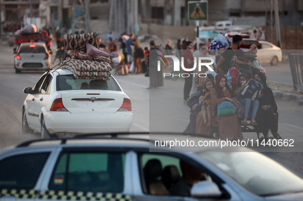 Displaced Palestinians are leaving al-Bureij refugee camp towards the west, after the Israeli army issued a new evacuation order, in the cen...