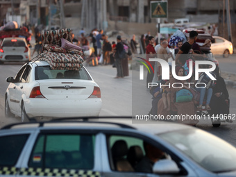 Displaced Palestinians are leaving al-Bureij refugee camp towards the west, after the Israeli army issued a new evacuation order, in the cen...