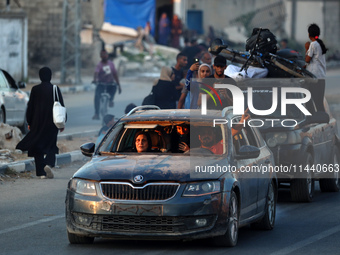 Displaced Palestinians are leaving al-Bureij refugee camp towards the west, after the Israeli army issued a new evacuation order, in the cen...