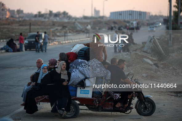 Displaced Palestinians are leaving al-Bureij refugee camp towards the west, after the Israeli army issued a new evacuation order, in the cen...