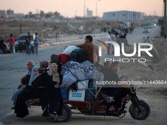 Displaced Palestinians are leaving al-Bureij refugee camp towards the west, after the Israeli army issued a new evacuation order, in the cen...