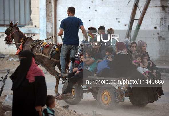 Displaced Palestinians are leaving al-Bureij refugee camp towards the west, after the Israeli army issued a new evacuation order, in the cen...