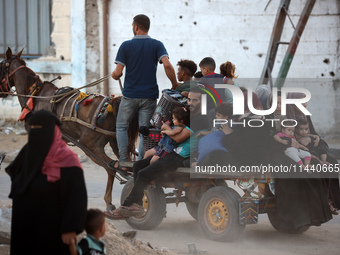 Displaced Palestinians are leaving al-Bureij refugee camp towards the west, after the Israeli army issued a new evacuation order, in the cen...