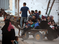 Displaced Palestinians are leaving al-Bureij refugee camp towards the west, after the Israeli army issued a new evacuation order, in the cen...