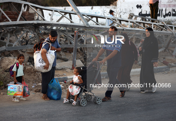 Displaced Palestinians are leaving al-Bureij refugee camp towards the west, after the Israeli army issued a new evacuation order, in the cen...