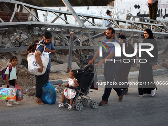 Displaced Palestinians are leaving al-Bureij refugee camp towards the west, after the Israeli army issued a new evacuation order, in the cen...