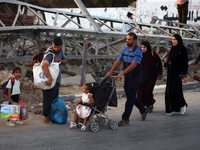 Displaced Palestinians are leaving al-Bureij refugee camp towards the west, after the Israeli army issued a new evacuation order, in the cen...