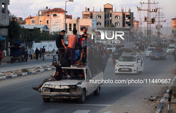 Displaced Palestinians are leaving al-Bureij refugee camp towards the west, after the Israeli army issued a new evacuation order, in the cen...