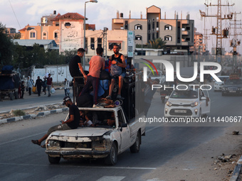 Displaced Palestinians are leaving al-Bureij refugee camp towards the west, after the Israeli army issued a new evacuation order, in the cen...