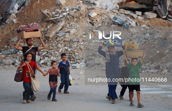 Displaced Palestinians are leaving al-Bureij refugee camp towards the west, after the Israeli army issued a new evacuation order, in the cen...