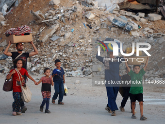 Displaced Palestinians are leaving al-Bureij refugee camp towards the west, after the Israeli army issued a new evacuation order, in the cen...