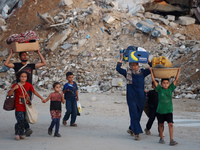 Displaced Palestinians are leaving al-Bureij refugee camp towards the west, after the Israeli army issued a new evacuation order, in the cen...