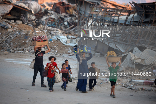 Displaced Palestinians are leaving al-Bureij refugee camp towards the west, after the Israeli army issued a new evacuation order, in the cen...