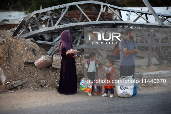 Displaced Palestinians are leaving al-Bureij refugee camp towards the west, after the Israeli army issued a new evacuation order, in the cen...