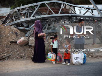 Displaced Palestinians are leaving al-Bureij refugee camp towards the west, after the Israeli army issued a new evacuation order, in the cen...