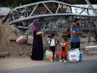 Displaced Palestinians are leaving al-Bureij refugee camp towards the west, after the Israeli army issued a new evacuation order, in the cen...