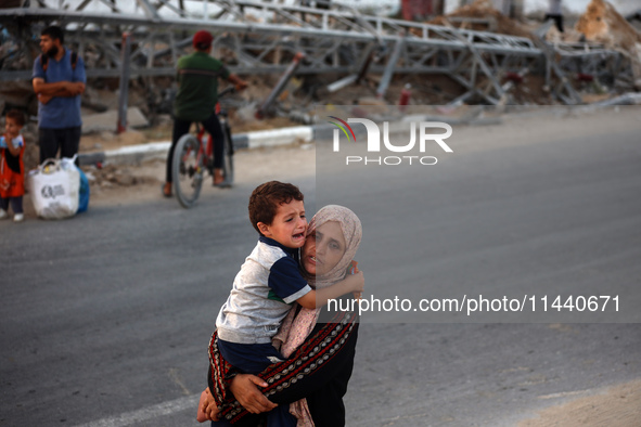 Displaced Palestinians are leaving al-Bureij refugee camp towards the west, after the Israeli army issued a new evacuation order, in the cen...